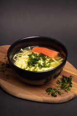homemade broth sprinkled with parsley in an elegant black bowl o