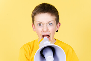Angry boy shouting on megaphone and looking straight to camera