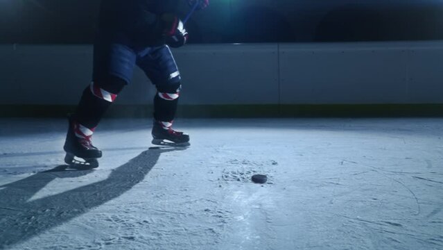 Ice Hockey Rink Arena: Professional Player Shooting, Hitting, Stricking the Puck with Hockey Sticks. Dramatic Close up Shot, Cinematic Lighting, 3D Puck Flying in Slow Motion. 2 in 1 pack
