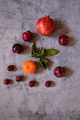 Still Life lemons, oranges and flowers composition in a dark stone background
