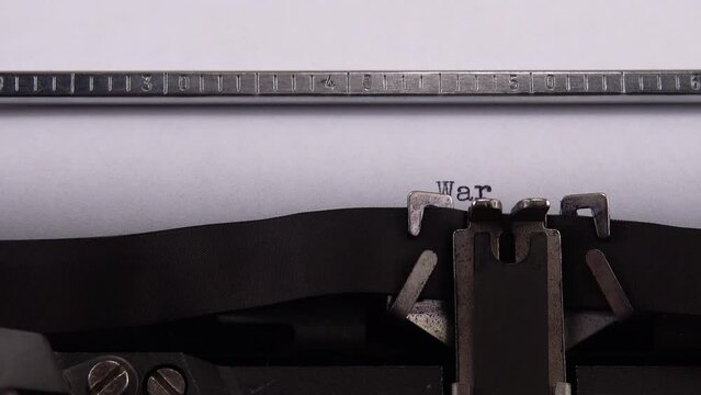 Typing phrase "War in Ukraine" on retro typewriter.