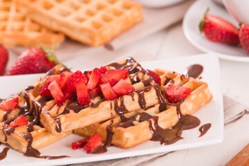 Waffles with strawberries and chocolate cream.