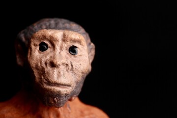 close up portrait of a primitive man doll on a black background