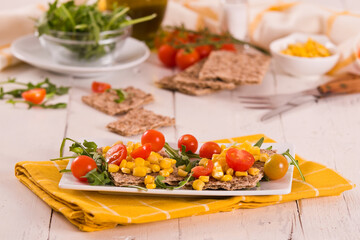 Crispy rye bread with sesame seeds, arugula and sweet corn.