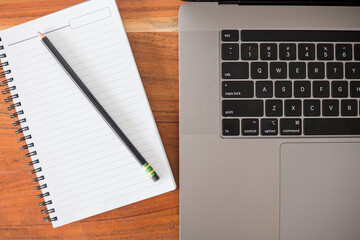 notebook and pencil with laptop