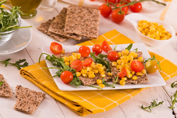 Crispy rye bread with sesame seeds, arugula and sweet corn.