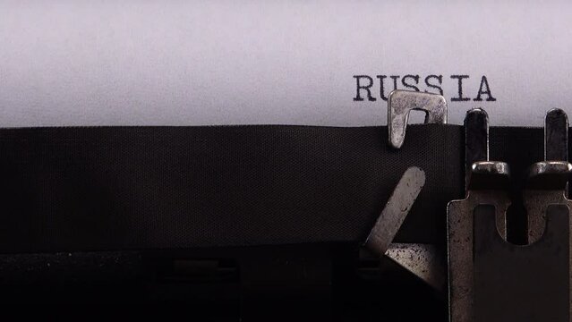 Typing phrase "RUSSIA vs UKRAINE" on retro typewriter.