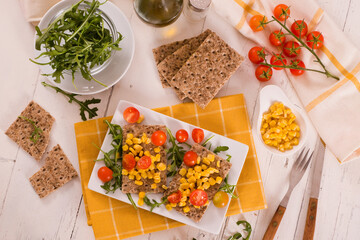 Crispy rye bread with sesame seeds, arugula and sweet corn.
