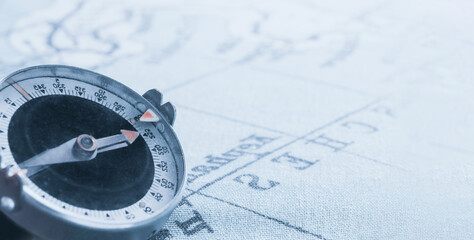 Magnetic old compass on world vintage  map.Travel, geography, navigation, tourism and exploration concept background.Macro shot, shallow focus.