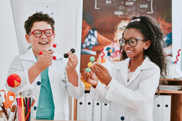 Theres never a dull moment when science is involved. Shot of two adorable young school children learning about molecules in science class at school. - Powered by Adobe
