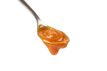 Liquid caramel on spoon. Caramel drips from the spoon. Pouring sweet caramel sauce. Texture, Close...
