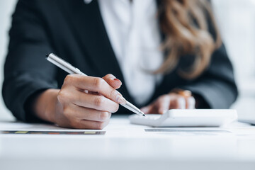 Business woman holding financial documents, she owns a startup company, she sits checking the company's financial summary prepared by the finance department. Management concept of startup company.