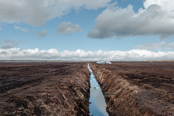 Drainage ditch in the peat extraction site. Drainage and destruction of peat bogs