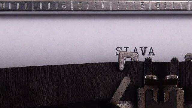 Typing Ukrainian greeting and slogan "SLAVA UKRAINI ! HEROIAM SLAVA !" on retro typewriter.
