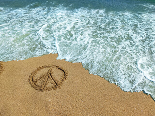 pacifist sign on the wet sand at the water's edge