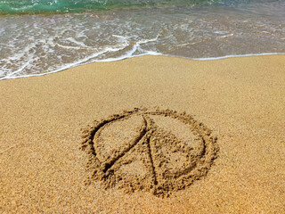 pacifist sign on the wet sand at the water's edge