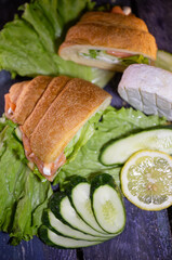 Top view of delicious homemade croissants with salmon and fresh salad on a wooden background.
