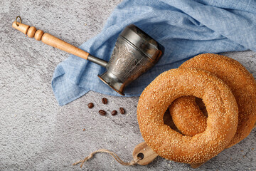 Traditional baked turkish simit sesame bagels and a cezve for the coffee on stone background