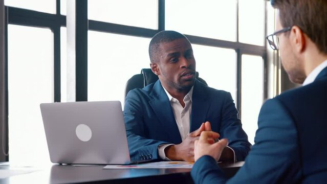 Young african american man hiring new colleague shaking hands after successful job interview