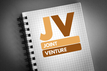 JV - Joint Venture acronym on notepad, business concept background