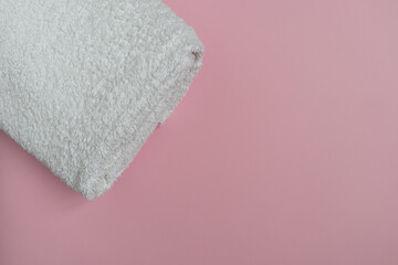 A white terry towel on a pink background with a place for text. Purity.