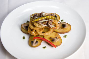 Fried onion rings in batter with potatoes and champignon mushrooms, with meat and fresh sweet pepper