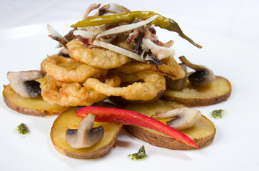 Fried onion rings in batter with potatoes and champignon mushrooms, with meat and fresh sweet pepper