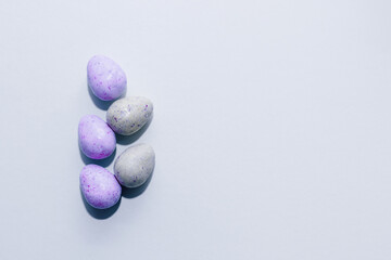 Purple lavender chocolate easter candy eggs on paper background.