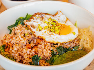 Close up shot of oat rice with nuts and sunny egg