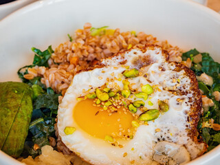 Close up shot of oat rice with nuts and sunny egg