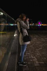 photo journalist professional photographer taking photographs at night in the city with lights in...