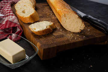 Baguette sliced with butter on a wooden board