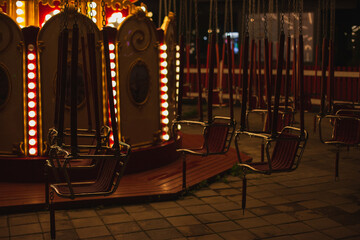 Carousel merry-go-round closeup with empty seats at night with motion blur on Christmas fair market...