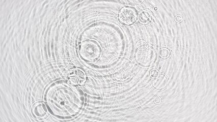 Multiple drops falling in water making multiple concentric waves on grey background | makeup background, micellar cleansing water commercial