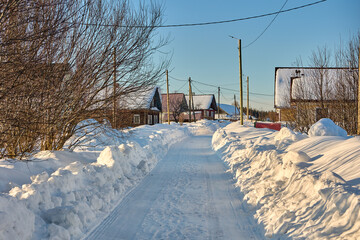 Snowy road in countryside with snowdrifts near in winter.