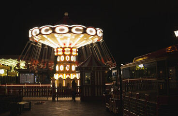 Carousel merry-go-round at night with motion blur on Christmas fair market on holiday season