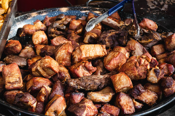 Roast pork, traditional Romanian food. Meat slices frying in a large pot.