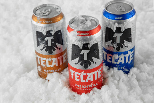 Mexico ,CDMX - April 08, 2022: Cans of original, light and amber tecate beer with frosty ice and with copy space
