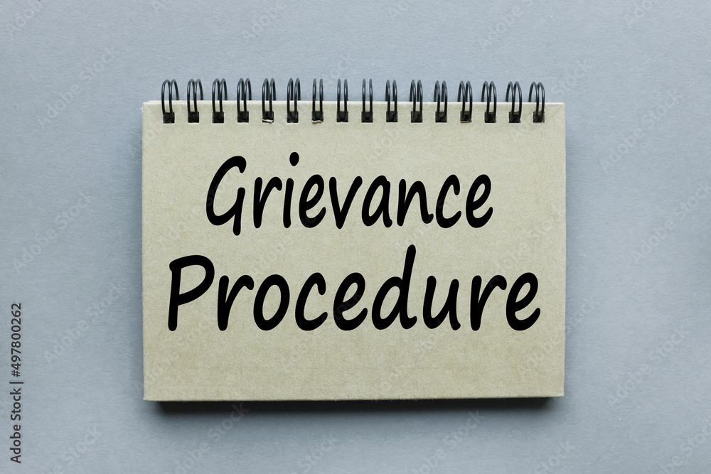 Poster grievance procedure text on a gray notepad on a gray background in black letters
