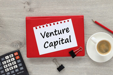 venture capital text on white paper on red notepad