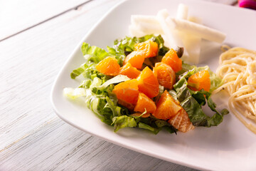 Fresh mixed lettuce and tangerine salad, accompanied by jicama 
