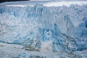Kalbende Gletscher, aus dem blauen Gletschereis des Perito Moreno Gletschers in Patagonien bricht ein riesiges Stück Eis heraus