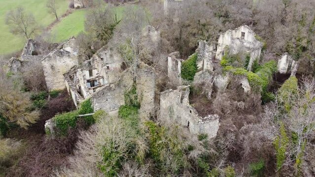 Aerial video of the ruined village called "Santa Olaria de Ara" in Huesca, Spain, mixed with vegetation.
