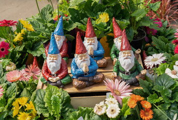 A store display of happy, dreamy ceramic gnomes surrounded by colorful flowers