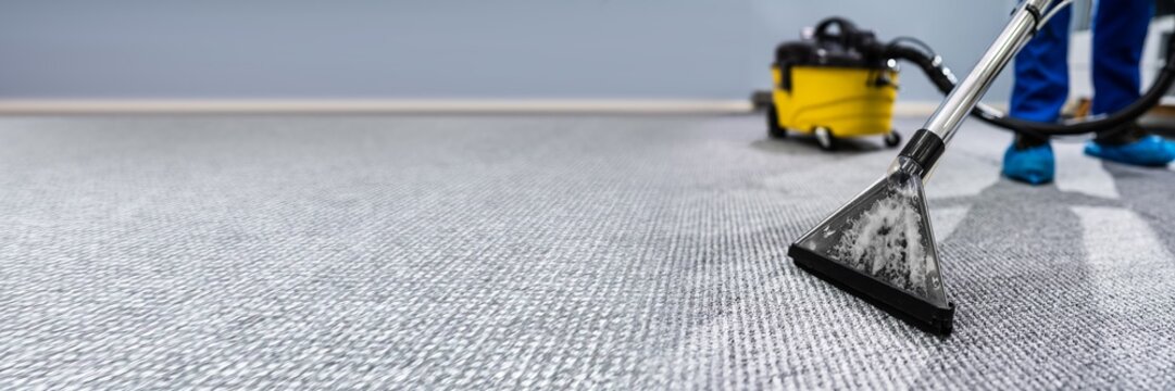 Person Cleaning Carpet With Vacuum Cleaner