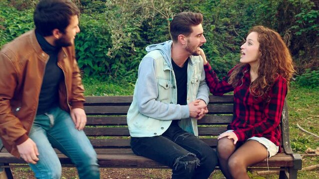 young man talking to a young woman is excluded when a mutula friend arrives