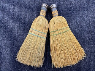 Two small brooms. Device for cleaning apartment and sweeping floor. Concept of cleanliness and...