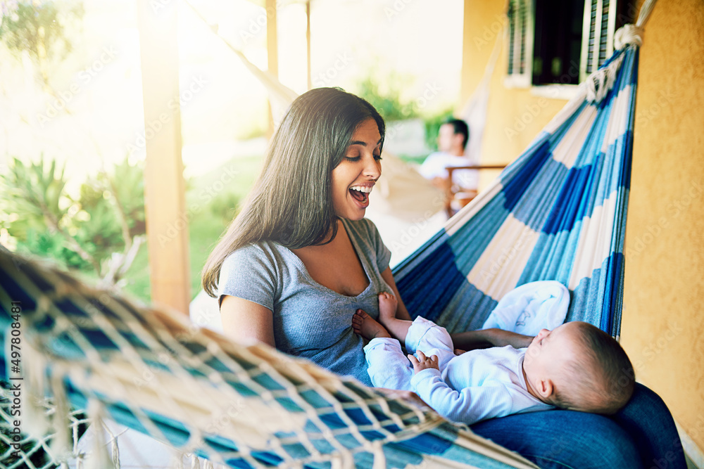 Poster Such a good boy. Shot of a cheerful young mother relaxing on a hammock with her infant son outside at home during the day.