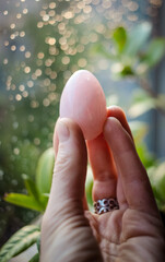 woman holding a rose quartz yoni egg