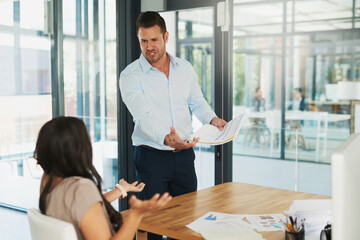 You call this a sales report. Shot of an angry businessman confronting his colleague about paperwork in the office.